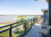 Thumbnail 28 of 47 - a balcony with chairs and a view of a river and a bridge