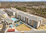 Thumbnail 28 of 29 - A large apartment complex with a pool and a playground.