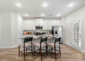 Thumbnail 2 of 29 - A kitchen with a table and chairs in the middle of it.