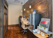 Thumbnail 27 of 42 - an office with a refrigerator and a desk with a chair and a table with chairs