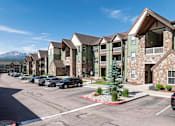 Thumbnail 1 of 42 - A row of apartment buildings with cars parked in front.