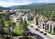 Thumbnail 40 of 42 - A large apartment complex with a parking lot in front of it.