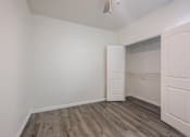 Thumbnail 26 of 35 - A room with a wooden floor and white walls.