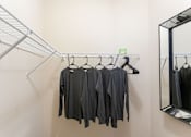Thumbnail 14 of 25 - A row of black shirts hanging on a rack in a store.
