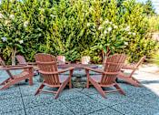 Thumbnail 18 of 25 - Four chairs and a table are set up on a patio.