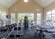 Thumbnail 6 of 25 - A gym with treadmills, exercise bikes, and a television.