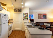 Thumbnail 8 of 25 - Apartments in Johnson City, TN, with In-Unit Washer and Dryer - University Edge - Fully Furnished Kitchen And Living Area With White Cabinets, Breakfast Bar, Double Sink, And Range And Refrigerator.