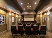 Thumbnail 5 of 25 - A movie theater with red seats and a screen.