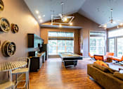 Thumbnail 3 of 25 - Fully Furnished Apartments for Rent in Johnson City, TN - University Edge - Activity And Club Room With Billiards Table, Lounge Seating, Vaulted Ceiling, Modern Lighting, And Large Windows.