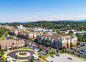 Thumbnail 25 of 25 - A large building complex with a circular driveway in front.