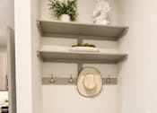 Thumbnail 20 of 30 - A white wall with a shelf and a pillow with a Texas flag on it.