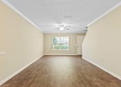 Thumbnail 5 of 18 - A room with wooden flooring and a ceiling fan.