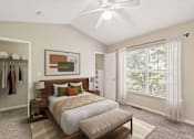 Thumbnail 4 of 18 - A bedroom with a large bed and a ceiling fan.