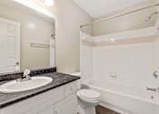 Thumbnail 7 of 18 - A bathroom with a sink, toilet, and bathtub.