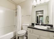 Thumbnail 9 of 35 - A white toilet sits next to a sink in a bathroom.
