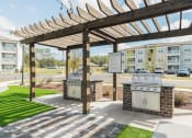 Thumbnail 29 of 35 - two bbq pits at the clubhouse of an apartment building with awning