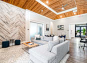 Thumbnail 6 of 43 - A living room with a white couch and a wooden ceiling.