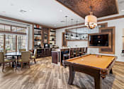 Thumbnail 4 of 44 - A billiard table is in the middle of a room with a bar and a dining table.