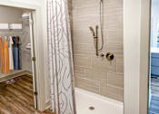 Thumbnail 17 of 70 - A bathroom with a shower curtain and a white bathtub.