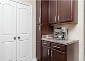 Thumbnail 30 of 44 - A kitchen with brown cabinets and a marble countertop.