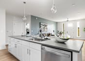 Thumbnail 26 of 79 - A modern kitchen with a large island and stainless steel appliances.