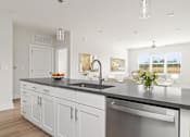 Thumbnail 49 of 79 - A modern kitchen with white cabinets and a black countertop.