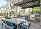 Thumbnail 16 of 30 - a patio with a table and chairs and a grill