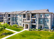 Thumbnail 18 of 18 - an apartment building with green lawns and a blue sky