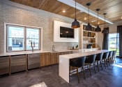 Thumbnail 16 of 35 - a kitchen with brick walls and a long island with a long white countertop