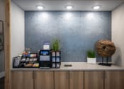 Thumbnail 18 of 35 - a lobby with a coffee machine and a wall with a blue patterned wall paper