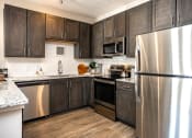 Thumbnail 2 of 35 - a kitchen with dark cabinets and stainless steel appliances