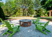 Thumbnail 28 of 36 - Luxury Apartments in Greenville, SC - Velo Verdae - Firepit with Adirondack Chairs and Surrounding Trees