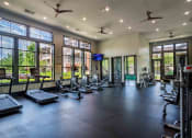 Thumbnail 6 of 36 - a gym with cardio equipment and windows in a building