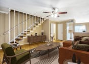 Thumbnail 5 of 13 - a living room with a staircase and a couch