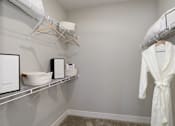 Thumbnail 10 of 31 - A white robe is hanging on a rack in a room.