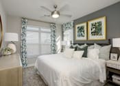 Thumbnail 6 of 31 - A bedroom with a white bed and green pillows.
