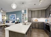 Thumbnail 3 of 31 - A modern kitchen with a white countertop and stainless steel appliances.