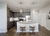Thumbnail 1 of 31 - A kitchen with a bar stool in front of the island.