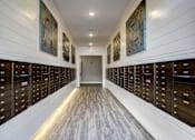 Thumbnail 24 of 31 - A hallway with a series of mailboxes on the wall.