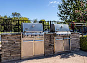Thumbnail 21 of 31 - two stainless steel gas grills on a stone wall with two stoves