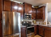 Thumbnail 3 of 28 - a kitchen with stainless steel appliances and wooden cabinets