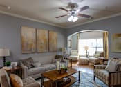 Thumbnail 4 of 28 - a living room with couches and a ceiling fan