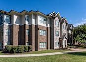 Thumbnail 23 of 28 - a brick apartment building with a sidewalk in front of it