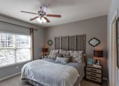 Thumbnail 8 of 28 - a bedroom with a bed and a ceiling fan