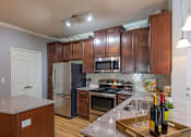 Thumbnail 2 of 28 - a kitchen with stainless steel appliances and granite counter tops