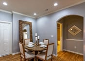 Thumbnail 6 of 28 - a dining room with a table and chairs and a mirror