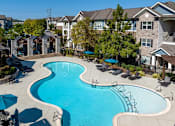 Thumbnail 16 of 28 - an aerial view of a swimming pool with umbrellas in front of a house
