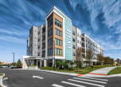 Thumbnail 1 of 48 - a large apartment building with a blue sky in the background