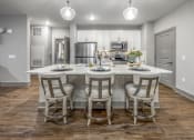 Thumbnail 15 of 48 - an open kitchen with a large island with chairs around it