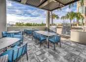 Thumbnail 23 of 48 - a patio with tables and chairs and a grill